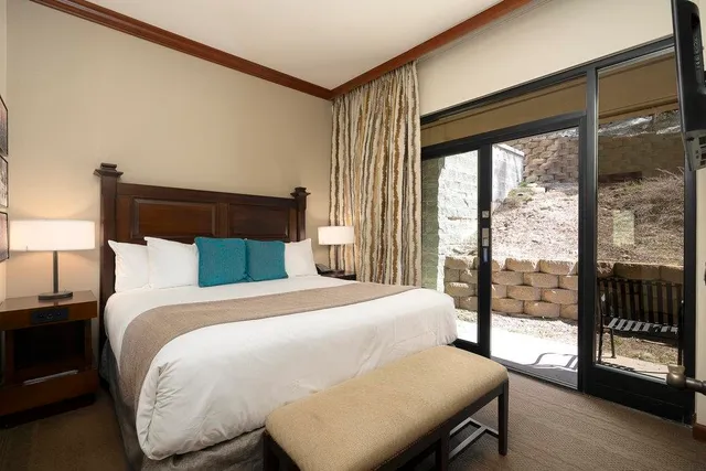 a bedroom with a bed and a large window