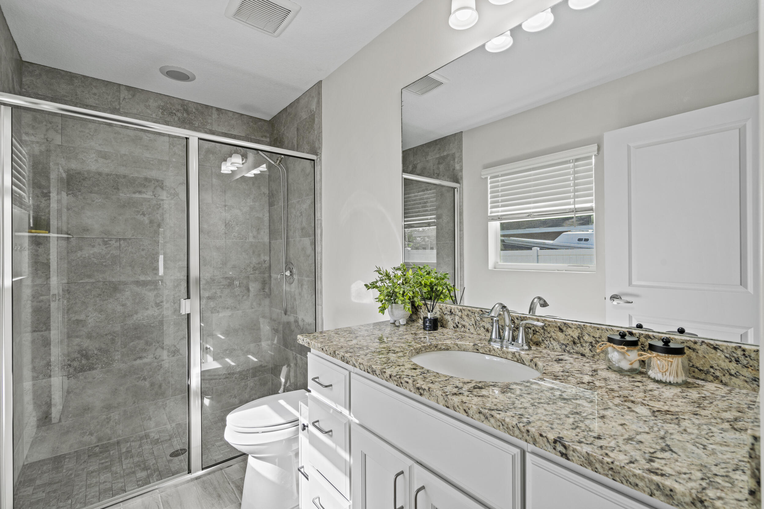 643 Southwest Curry Street Port St. Lucie, FL 34983 - Photo 11 of 21 a bathroom with a granite countertop sink toilet and shower