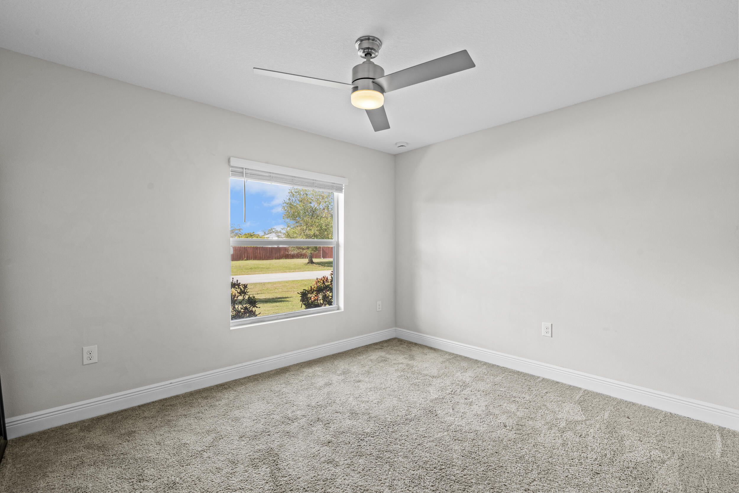 643 Southwest Curry Street Port St. Lucie, FL 34983 - Photo 13 of 21 an empty room with windows and fan