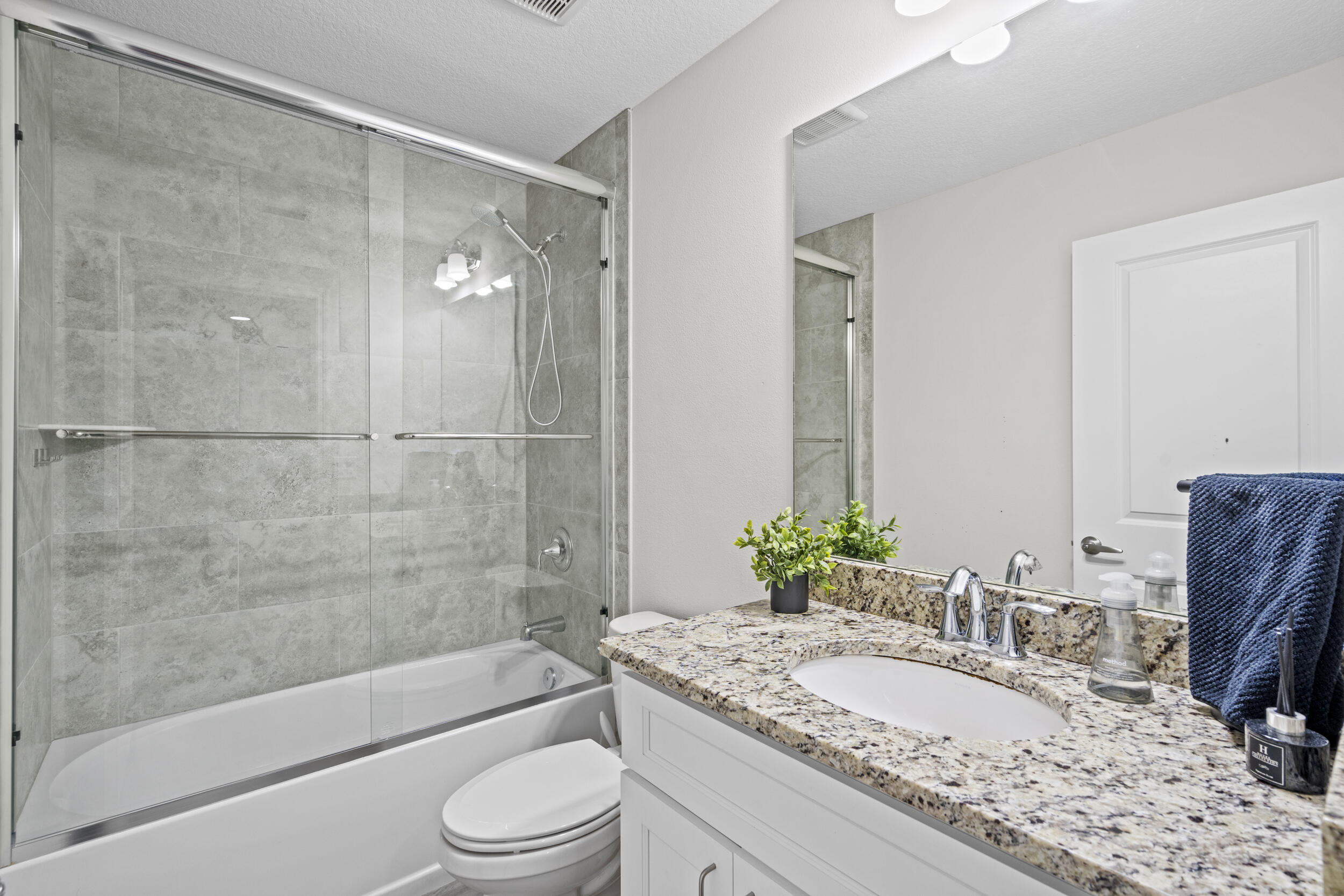 643 Southwest Curry Street Port St. Lucie, FL 34983 - Photo 14 of 21 a bathroom with a granite countertop sink toilet mirror and bathtub