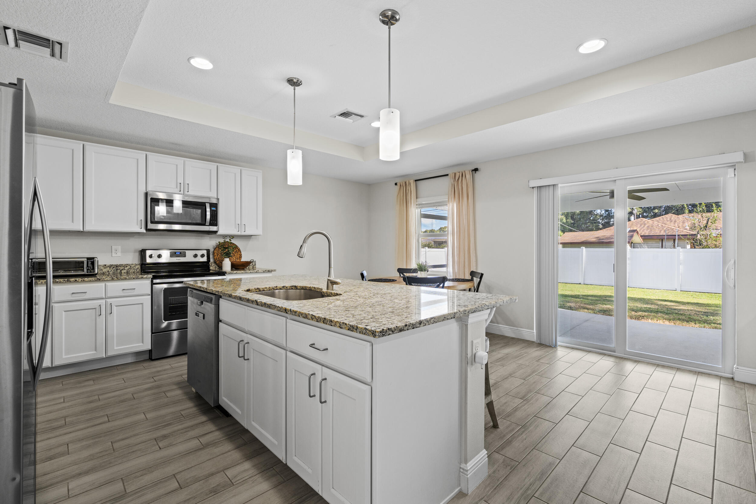 643 Southwest Curry Street Port St. Lucie, FL 34983 - Photo 4 of 21 a kitchen with granite countertop a stove a sink and a refrigerator