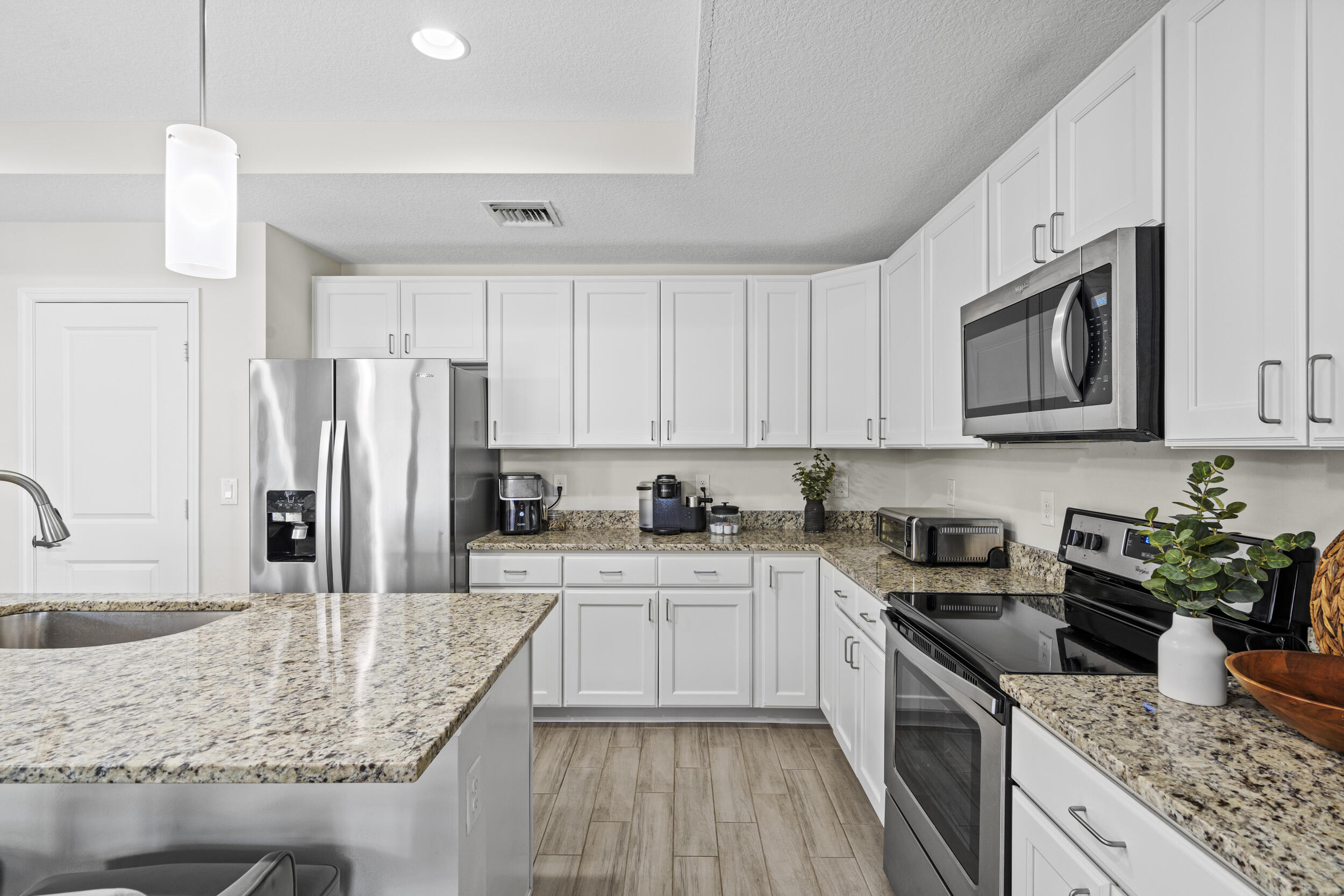 643 Southwest Curry Street Port St. Lucie, FL 34983 - Photo 5 of 21 a kitchen with stainless steel appliances granite countertop a sink stove microwave and refrigerator