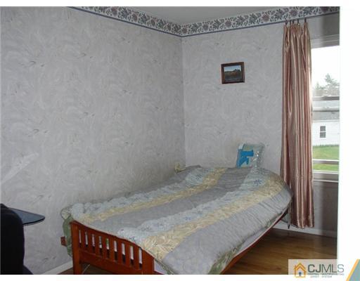 46 Woodbury Road Edison, NJ 08820 - Photo 14 of 18 a bedroom with a bed and a table in it