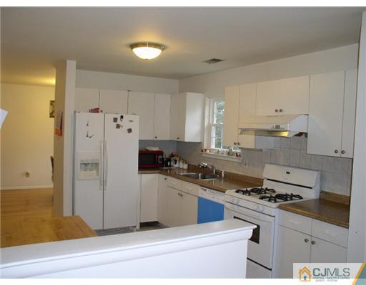 46 Woodbury Road Edison, NJ 08820 - Photo 5 of 18 a kitchen with stainless steel appliances a stove a refrigerator and cabinets