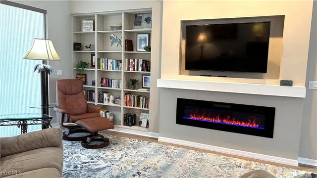 a living room with furniture a flat screen tv and a fireplace