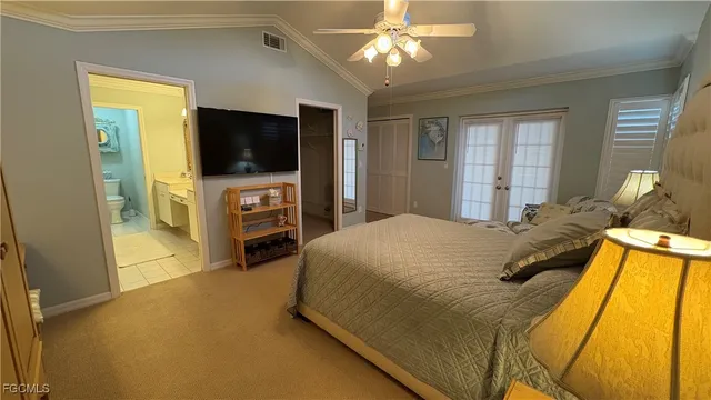 a spacious bedroom with a bed and a flat screen tv