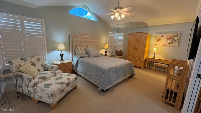 a bedroom with a bed mirror on dresser and a chandelier