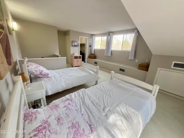 a bedroom with two beds and painting on the wall