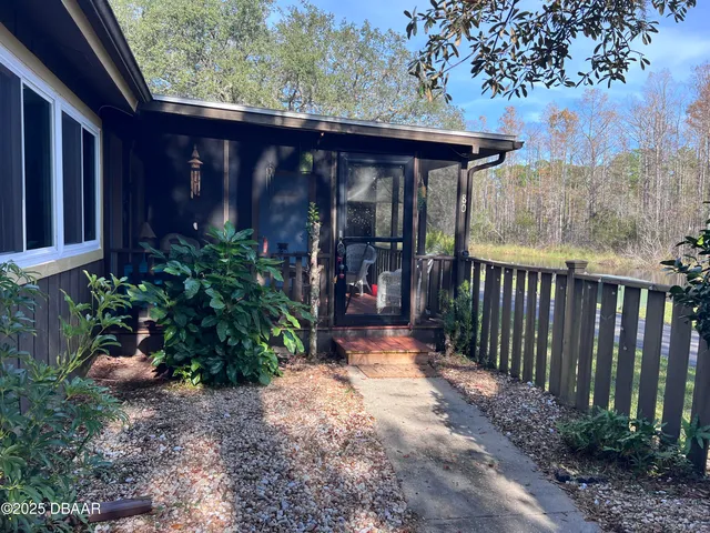 a view of a pathway with a small yard and wooden fence