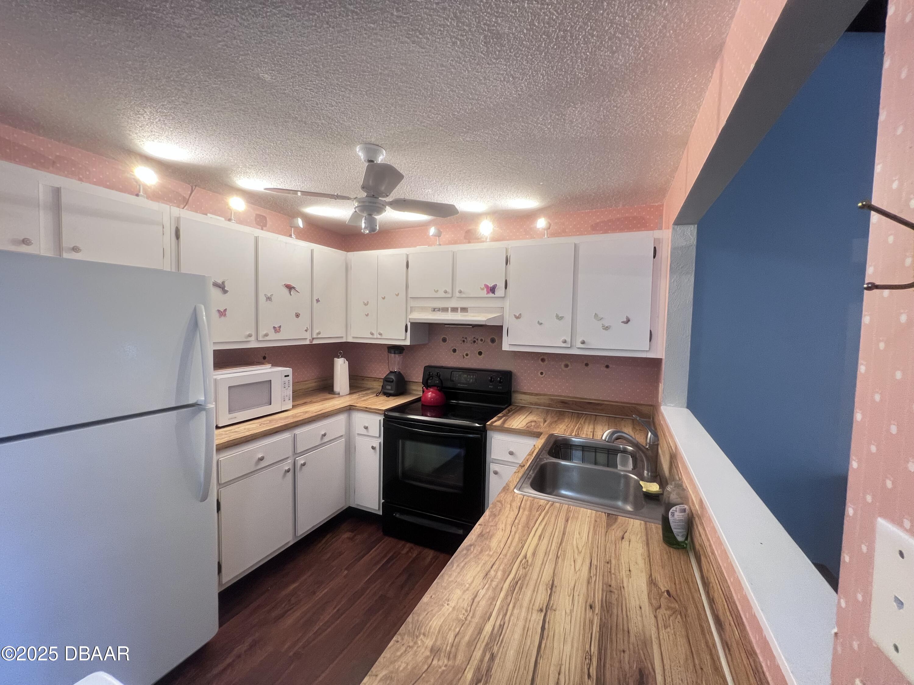 80 Cypress Pond Road Port Orange, FL 32128 - Photo 8 of 31 a kitchen with cabinets a sink and wooden floor