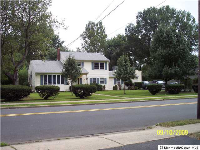 257 Harmony Road Middletown, NJ 07748 - Photo 2 of 3 a view of street with yellow house in front of it
