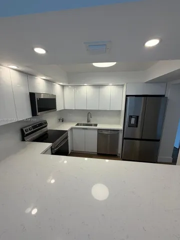 a kitchen with stainless steel appliances a refrigerator sink and microwave