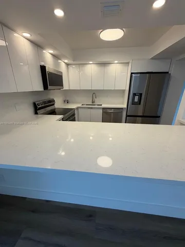 a view of kitchen with microwave and cabinets