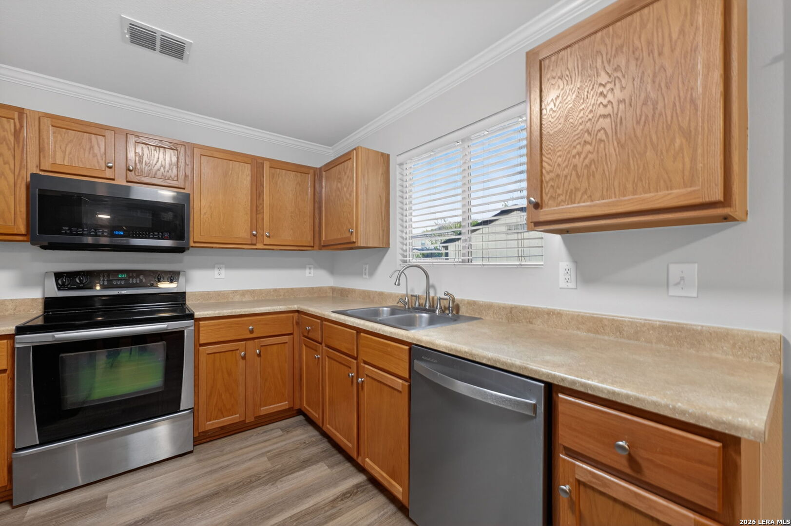 217 Willow Run Cibolo, TX 78108 - Photo 18 of 41 a kitchen with stainless steel appliances granite countertop a sink a stove a microwave and wooden cabinets