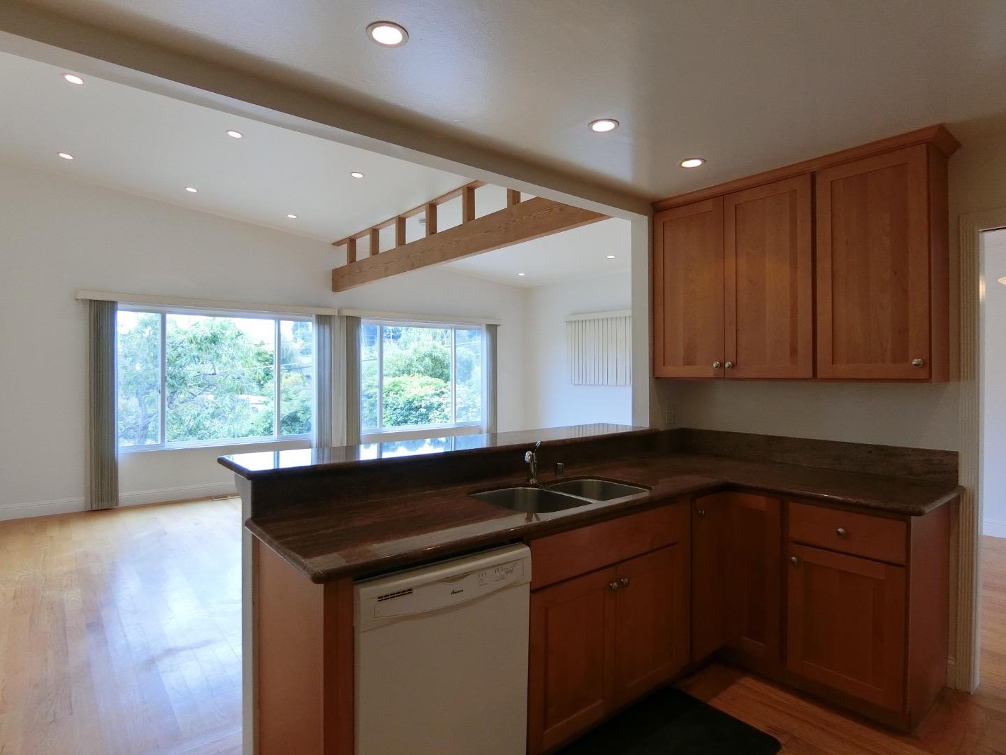 a kitchen with granite countertop sink cabinets and window
