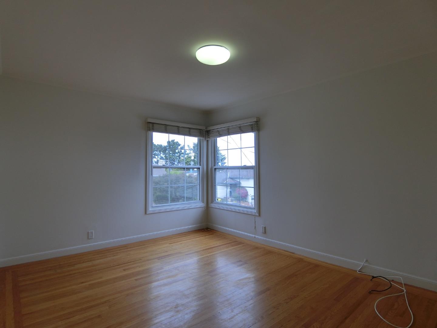 339 Paramount Drive Millbrae, CA 94030 - Photo 5 of 14 an empty room with wooden floor and windows