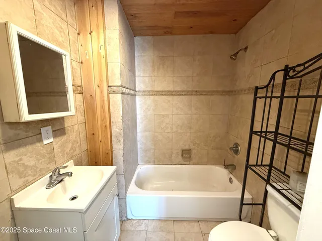 a bathroom with a tub a sink and mirror