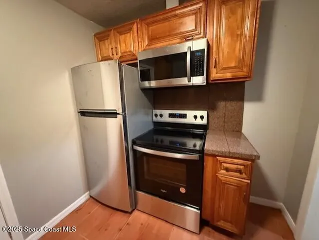 a kitchen with granite countertop a sink a stove and cabinets