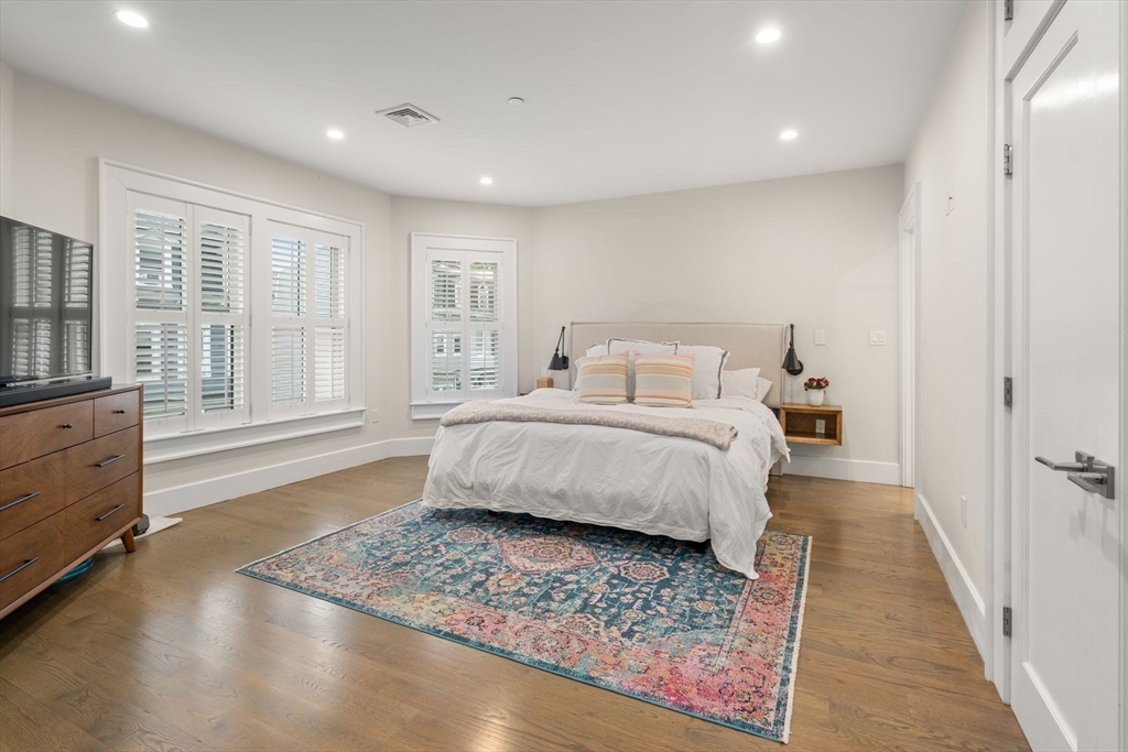 654 East 7th Street, Unit 3 Boston, MA 02127 - Photo 14 of 28 a spacious bedroom with a bed and wooden floor