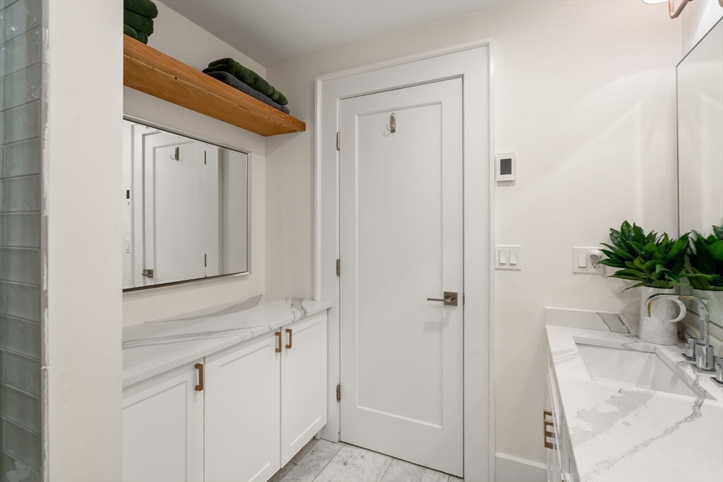 654 East 7th Street, Unit 3 Boston, MA 02127 - Photo 22 of 28 a bathroom with a granite countertop sink a mirror and shower
