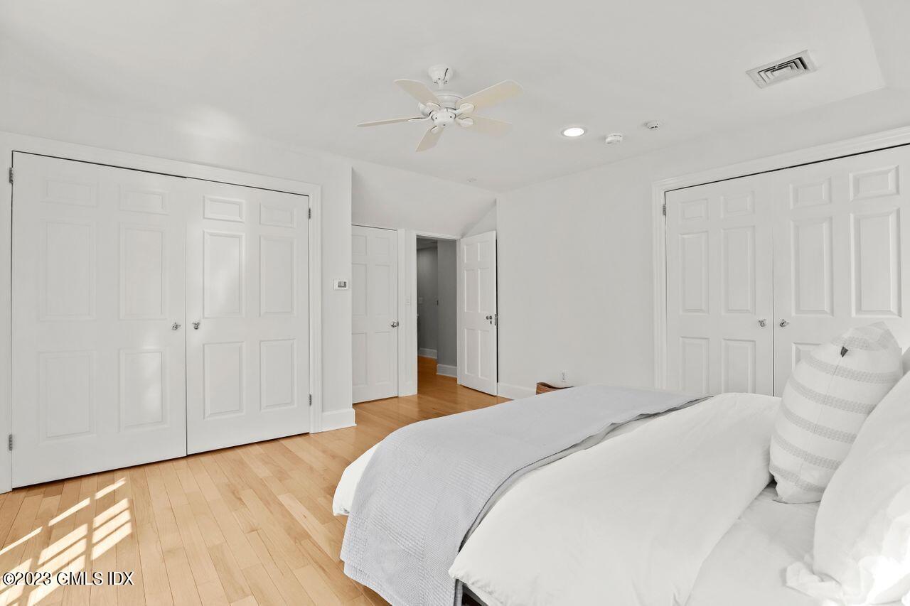22 Linwood Avenue Riverside, CT 06878 - Photo 18 of 37 a bedroom with a large bed and a chandelier