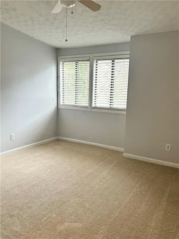 an empty room with a ceiling fan and window