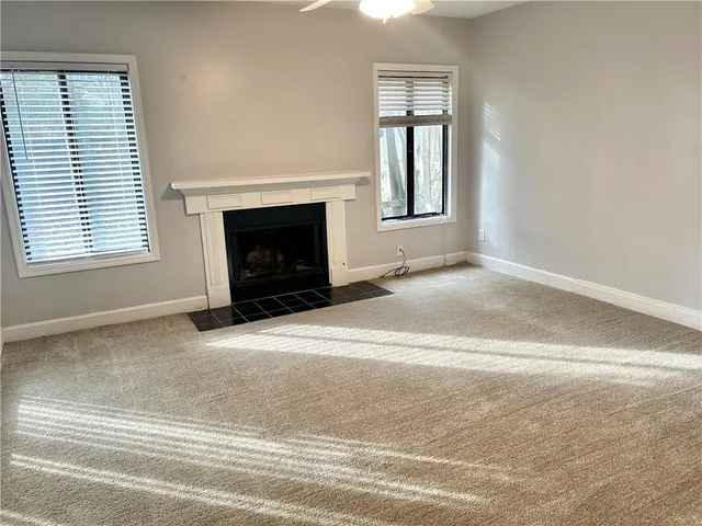 an empty room with a fireplace and window
