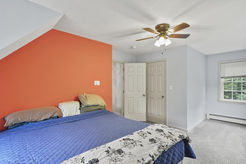 128 Green Farm Road New Ipswich, NH 03071 - Photo 23 of 39 a bedroom with a bed and a chandelier