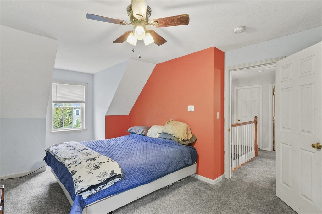 128 Green Farm Road New Ipswich, NH 03071 - Photo 24 of 39 a bedroom with a bed a window and a chandelier