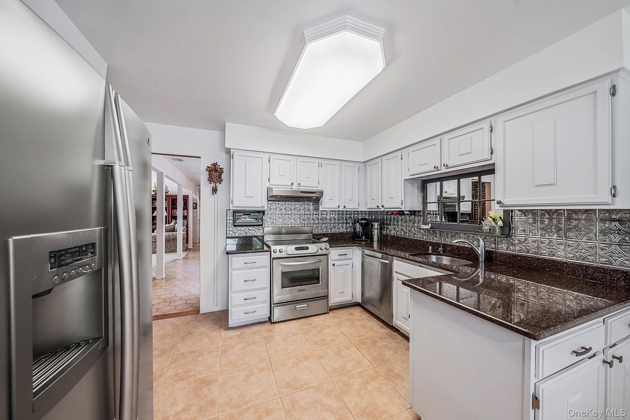 96 Fulton Boulevard Commack, NY 11725 - Photo 22 of 41 a kitchen with stainless steel appliances granite countertop a stove sink and refrigerator