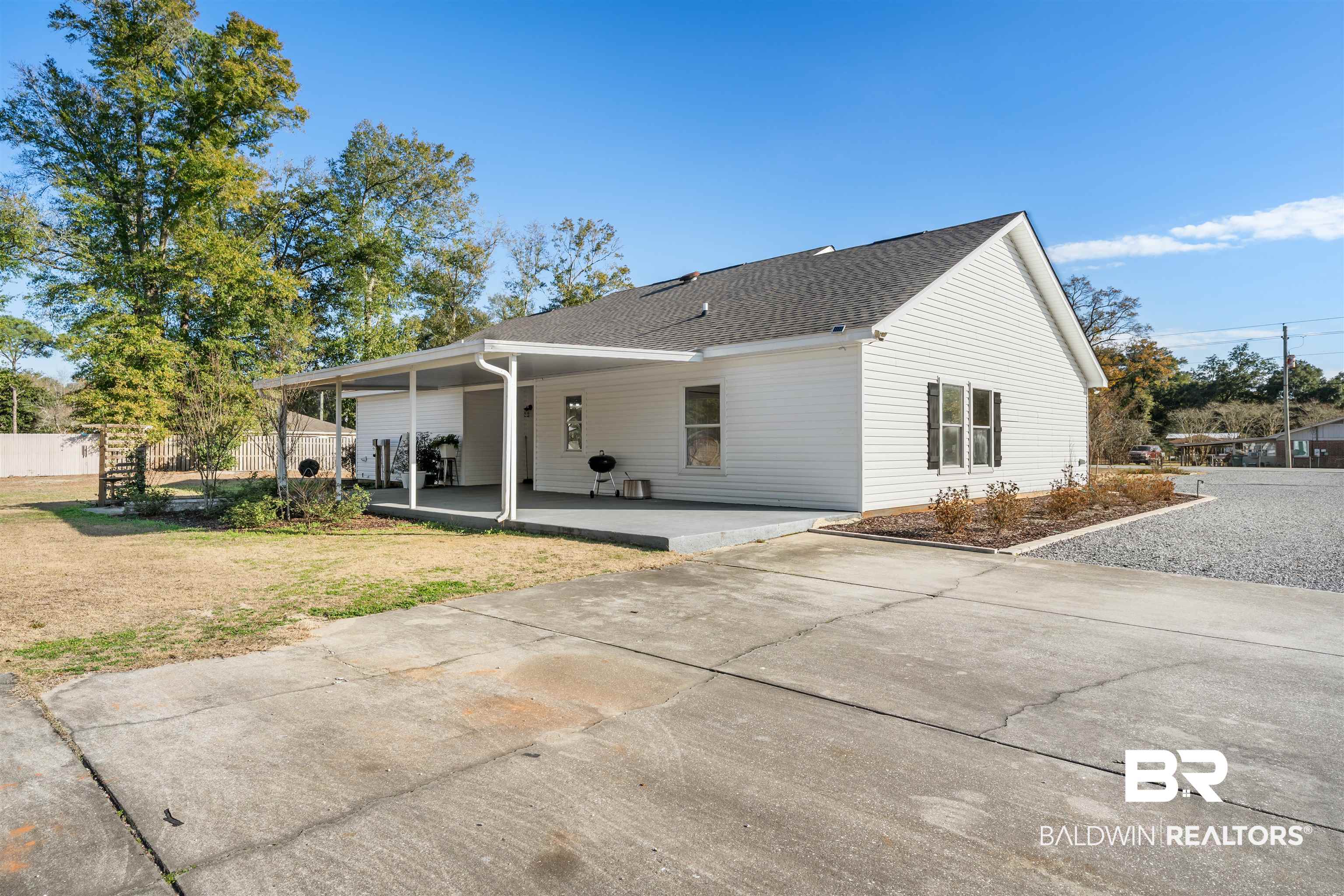 19079 Baldwin County Road 10 Foley, AL 36535 - Photo 35 of 37 View of home's exterior with a patio, roof with shingles, and driveway