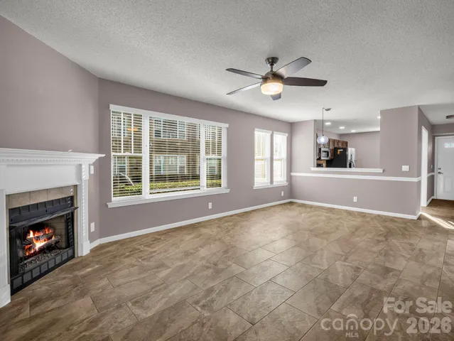 a view of an empty room with a fireplace and a window