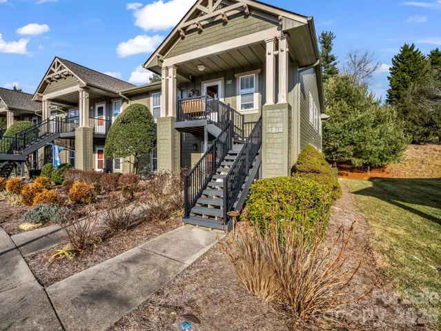 a view of a house with large windows and flower plants