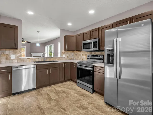 a kitchen with a refrigerator sink and stainless steel appliances