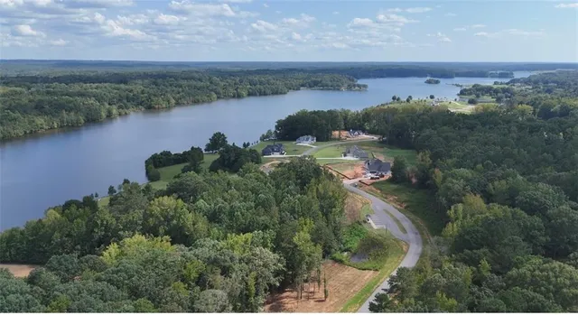 an aerial view of lake residential house with outdoor space and trees around