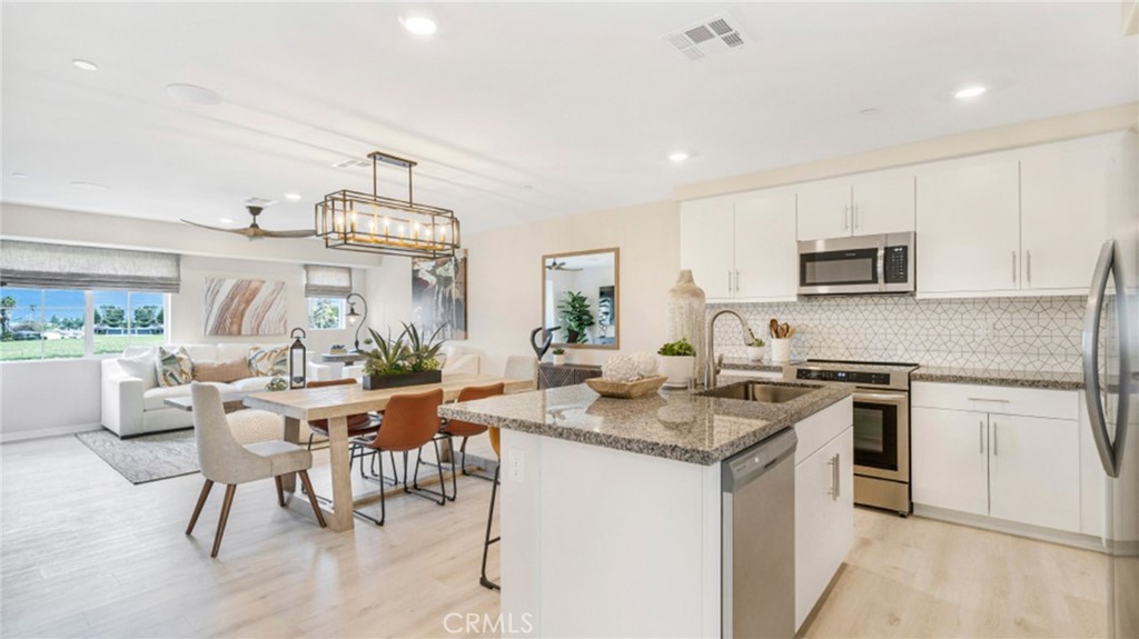 a kitchen with a stove a sink a dining table and chairs
