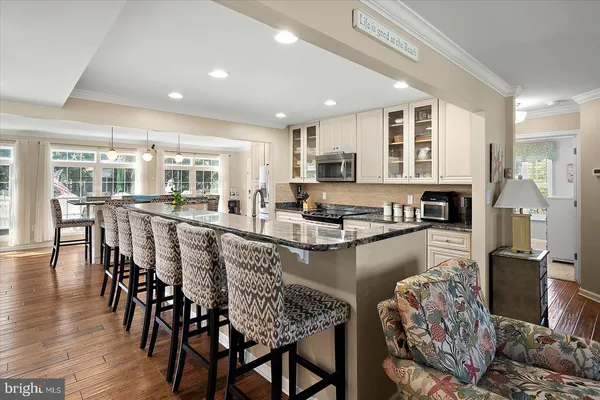 a dining room with furniture a chandelier and wooden floor