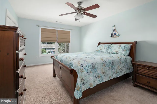a view of a brick house with a yard plants and a lawn chairs