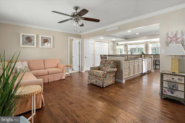 a living room with furniture a ceiling fan a fireplace and a large window