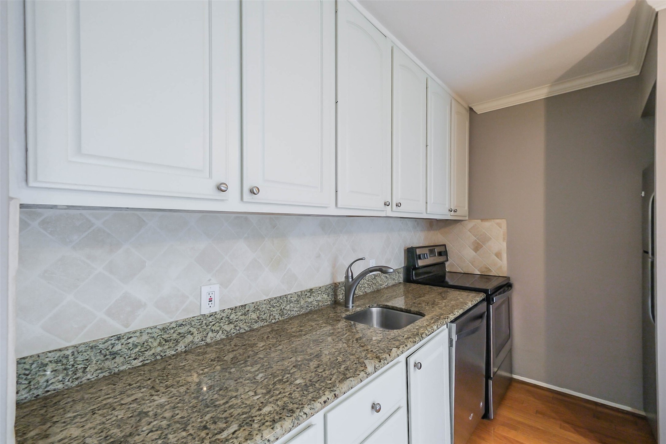 2230 South Piney Point Road, Unit 113 Houston, TX 77063 - Photo 7 of 28 The kitchen has granite counters and tile backsplash.