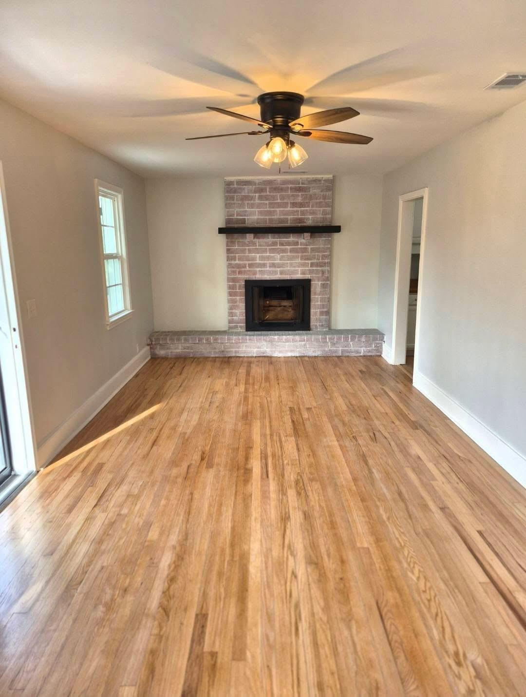 1434 Highway 57 Dillon, SC 29536 - Photo 2 of 9 Unfurnished living room featuring a ceiling fan, a fireplace, and light wood-style flooring
