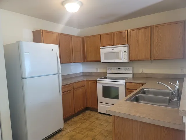 a kitchen with cabinets a refrigerator and a sink