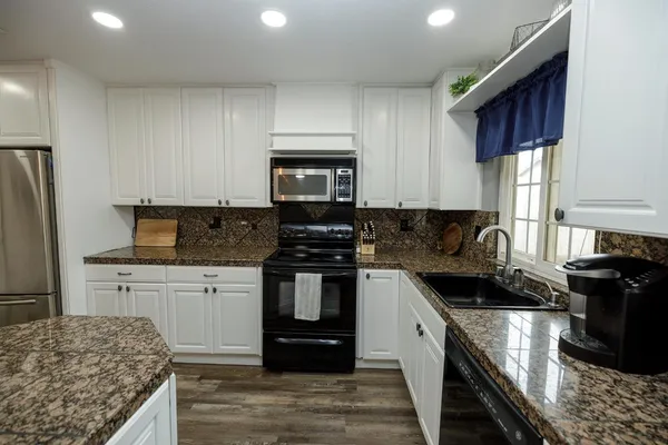 a kitchen with granite countertop stainless steel appliances and wooden cabinets
