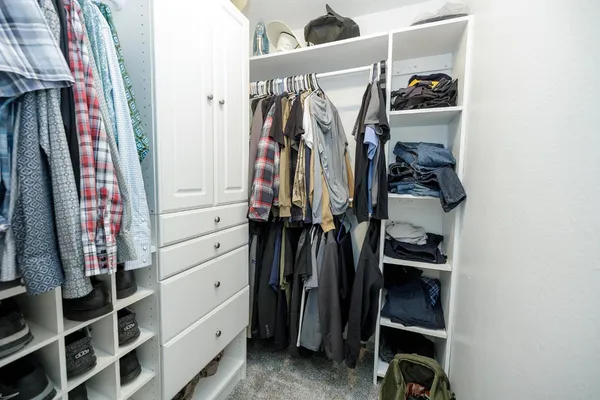 a view of walk in closet with clothes and shoes