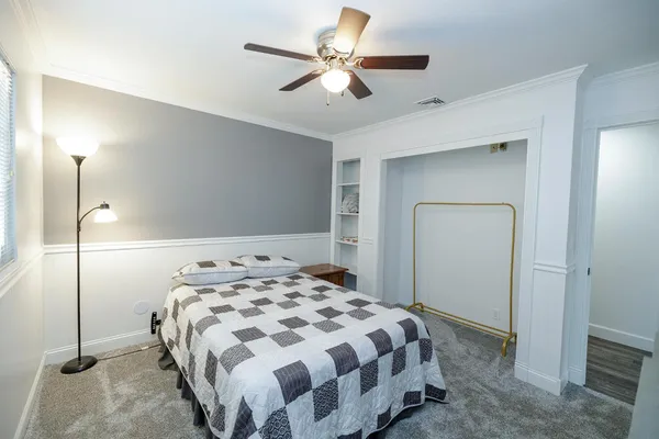 a bedroom with a bed and a ceiling fan