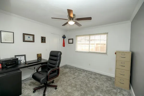 a view of a workspace with furniture and a window