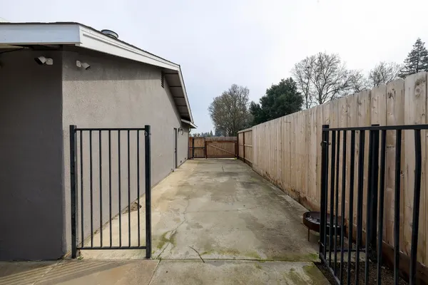 a side view of a house with backyard and trees