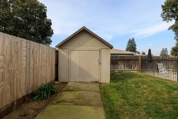 a view of backyard of house with wooden fence