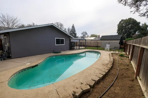 a swimming pool with outdoor seating and yard