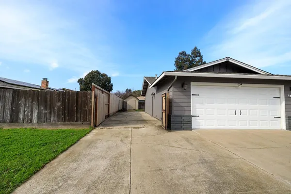 a view of a house with a yard and a large parking space